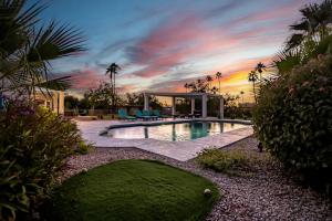 een zwembad in een tuin met palmbomen bij Scottsdale Golf Paradise -1 Acre of Fun 9-Hole Golf Course, Pickleball Court, Pool, Cornhole in Scottsdale