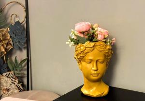 een gouden kop met bloemen erop bij NIK Rooms in Rome
