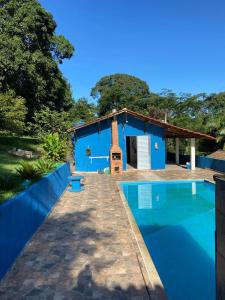 a blue house with a swimming pool in front of it at Recanto do Bira in Socorro