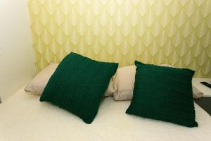 a bed with two green pillows on top of it at PC4008 - Apto moderno Tatuapé in Sao Paulo