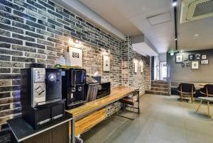 a large room with a brick wall and a counter with televisions at No 25 Hotel Gwangan in Busan
