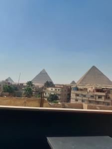 uma vista para as pirâmides a partir da janela de um quarto em Orion pyramids view no Cairo