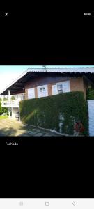 a building with a hedge in front of it at Casa Papai Noel in Campos do Jordão