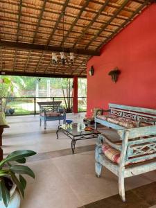 een kamer met een rode muur met banken en een tafel bij Villa Pietá in Brumadinho