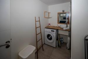 a bathroom with a sink and a washing machine at ILET TURQUOISE in Le Gosier +3 photos