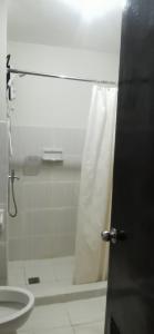 a bathroom with a shower curtain and a toilet at Mesaverte Residences "ZACE STUDIO" in Cagayan de Oro +2 photos