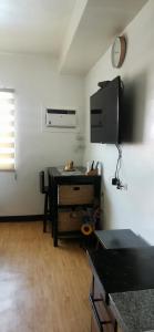 Zimmer mit einem Schreibtisch und einem TV in einem Zimmer in der Unterkunft Mesaverte Residences "ZEC STUDIO" in Cagayan de Oro