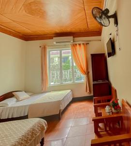 a bedroom with two beds and a window at New Sky Hotel in Dong Quan