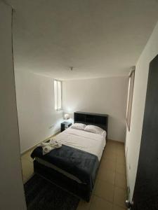 a bedroom with a bed in a white room at Departamento Lumina Sipeh Xalapa in Xalapa