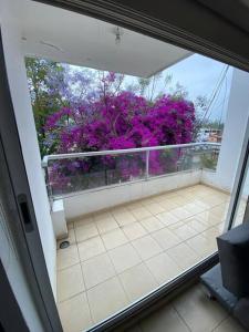 an open door to a balcony with purple flowers at Departamento Lumina Sipeh Xalapa in Xalapa