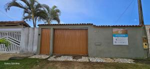a building with an orange door next to a fence at Casa temporada Guriri in São Mateus