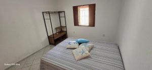 a bed with two pillows on it in a room at Casa temporada Guriri in São Mateus