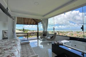 - une chambre avec une baignoire et une vue sur l'océan dans l'établissement 6 Suites, banheira, Piscina, no coração da Região dos Lagos, à São Pedro da Aldeia