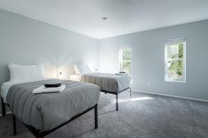 a white bedroom with two beds and two windows at Scottsdale Old Town Haven, Walk To Old Town & Fashion Square Mall, Pool & Concierge Service! in Scottsdale