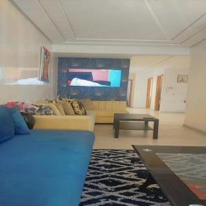 Yanis guest house في الدار البيضاء: غرفة معيشة مع أريكة وتلفزيون