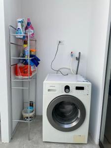 a washing machine in a room with a shelf at Modern Apartment close to the airport in Lima