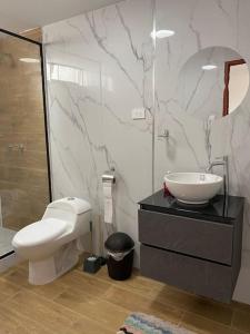 a bathroom with a toilet and a sink at Modern Apartment close to the airport in Lima