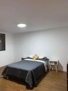 a bedroom with a bed and a white wall at Modern Apartment close to the airport in Lima