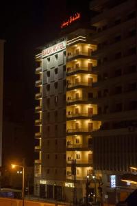 un edificio con un cartel de hotel por la noche en Badr Hotel Assiut, en Asiut