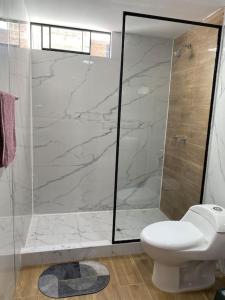 a white bathroom with a shower and a toilet at Modern Apartment close to the airport in Lima