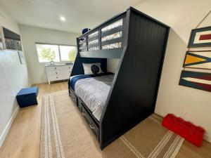 a bedroom with a black bunk bed in a room at SummerLillie #1 in Summerland