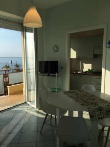 eine Küche und ein Esszimmer mit einem Tisch und einem Balkon in der Unterkunft Casa Isa a 30 metri dalla spiaggia in Borghetto Santo Spirito