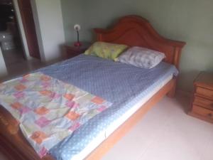 a bed with a blue comforter and two pillows at Casa de Descanso in Ricaurte