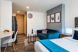 um quarto de hotel com uma cama e um sofá em Torre Acqua Lofts - Downtown Bogota em Bogotá