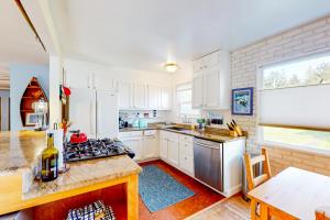 a kitchen with white cabinets and a stove top oven at Creeksong Retreat in Crescent City