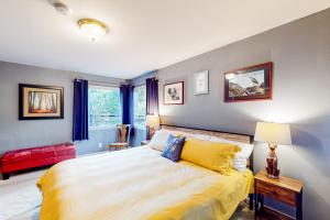 Creeksong Retreat في كريسنت سيتي: غرفة نوم بسرير كبير مع مخدات صفراء