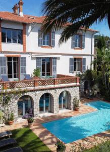 a large house with a swimming pool in front of it at Villa Persienne in Cannes
