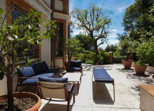 a patio with couches and a table and chairs at Villa Persienne in Cannes
