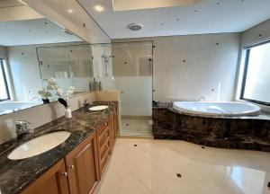 La grande salle de bains est pourvue de 2 lavabos et d'une baignoire. dans l'établissement 59 Lakeside Luxury Views 2br 2baparking, à Perth