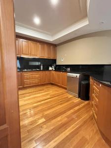 Il comprend une grande cuisine dotée de parquet et d'armoires en bois. dans l'établissement 59 Lakeside Luxury Views 2br 2baparking, à Perth