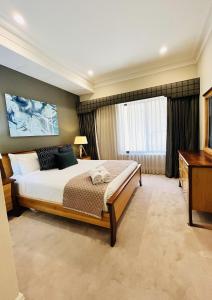 - une chambre avec un grand lit et un bureau dans l'établissement 59 Lakeside Luxury Views 2br 2baparking, à Perth