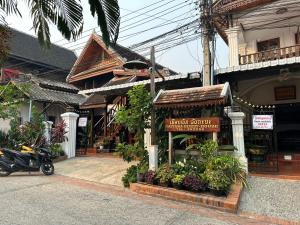 a store with a motorcycle parked in front of a building at Rattana Guesthouse in Luang Prabang