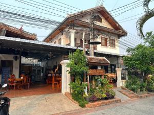 a building with a shop with plants in front of it at Rattana Guesthouse in Luang Prabang