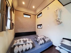 niewielka sypialnia z niebieskim łóżkiem i 2 poduszkami w obiekcie 森と湖の楽園ＷorkshopＣampＲesort w mieście Fujikawaguchiko