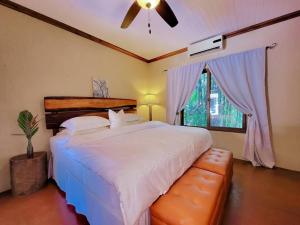 Un dormitorio con una gran cama blanca y una ventana en Vive Utila - Bed & Breakfast, en Utila