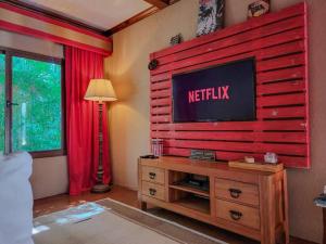 sala de estar con TV en la pared en Vive Utila - Bed & Breakfast en Utila