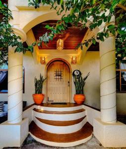 a entry to a house with two potted plants at Vive Utila - Bed & Breakfast in Utila