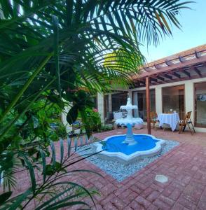 a garden with a fountain in the middle of a patio at Vive Utila - Bed & Breakfast in Utila