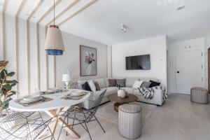 een woonkamer met een bank en een tafel bij AkomodaT en nuevo y precioso en Algorta con parking in Getxo