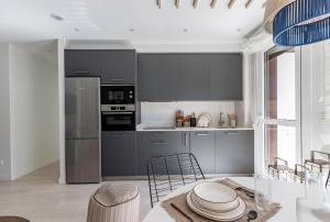 a kitchen with gray appliances and a table and chairs at AkomodaT en nuevo y precioso en Algorta con parking in Getxo