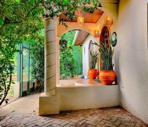 una casa con dos macetas en un arco en Vive Utila - Bed & Breakfast en Utila