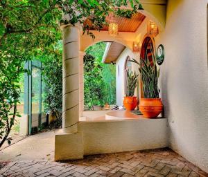 a house with two potted plants in an archway at Vive Utila - Bed & Breakfast in Utila