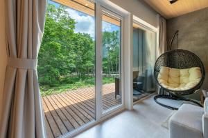 a room with a wicker chair in front of a sliding glass door at Japavista Rusutsu in Rusutsu