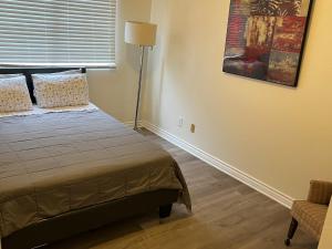 a bedroom with a bed and a lamp and a chair at 2bedroom & 1bath home near Universal Studio & Hollywood in Van Nuys