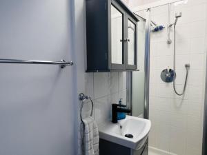 a white bathroom with a sink and a shower at Impeccable 1 Bedroom Flat in Central London in London