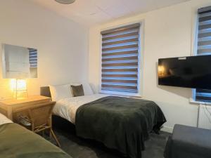 a bedroom with two beds and a flat screen tv at Impeccable 1 Bedroom Flat in Central London in London